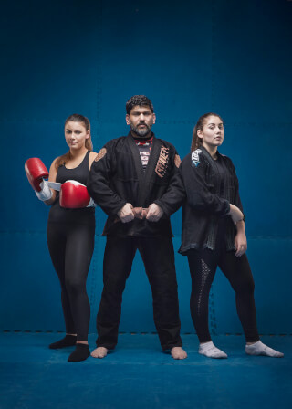 Three martial artists stand confidently in their gear, ready for training or competition, promoting fitness and discipline.
