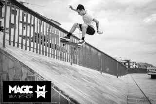 A skateboarder performs a trick on a handrail in an urban setting, captured in black and white for an energetic feel.