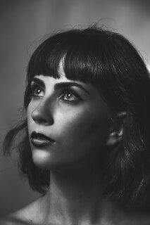Monochrome close-up portrait of a woman looking up with soft lighting, perfect for editorial or beauty campaigns.