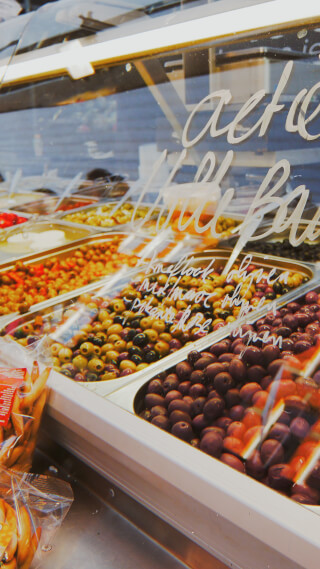 A close-up showcases colorful olives in a display case, perfect for food advertising and market promotions.