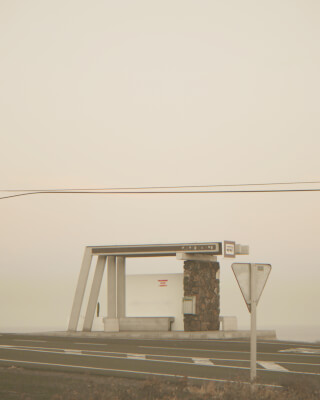A quiet roadside bus stop, set against a hazy sky, offering a serene travel moment.