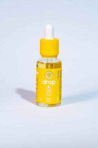 A bright and clean image of a Drop CBD oil bottle with a yellow label and white dropper, perfect for wellness campaigns.