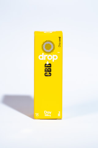 A yellow box of Drop CBD oil, a health supplement with chia seed, sits on a white surface.