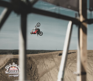 A motocross rider performs a stunt in the air at the Red Bull Dirt Diggers event.