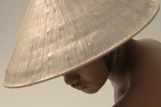 A person wearing a traditional Asian conical hat in a close-up portrait.