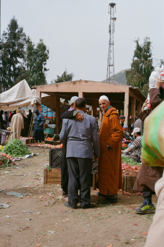 A bustling market scene captures local life and traditional commerce in an outdoor setting.