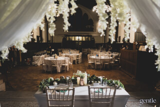 A beautifully decorated wedding reception venue with elegant tables and floral arrangements, ready for a celebration.