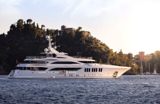 A luxury yacht sailing near the coastline. A perfect getaway for vacations and an escape from the routine.