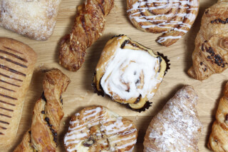 A delicious flat lay of assorted pastries, breads, and cinnamon rolls. Great for bakery and food-related promotions.