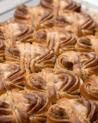 Delicious sweet rolls with poppy seeds and sugar glaze are captured in a close-up food photo.