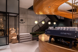 A modern coffee shop interior featuring coffee bags and a Sanremo Opera 2.0 espresso machine.