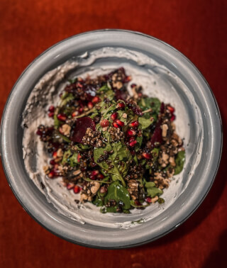 Overhead shot of a salad with pomegranate, quinoa and beetroot on a plate.