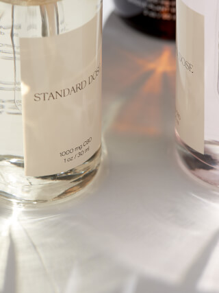 Close-up of Standard Dose CBD oil bottles, showcasing wellness and natural health in a minimalist style.