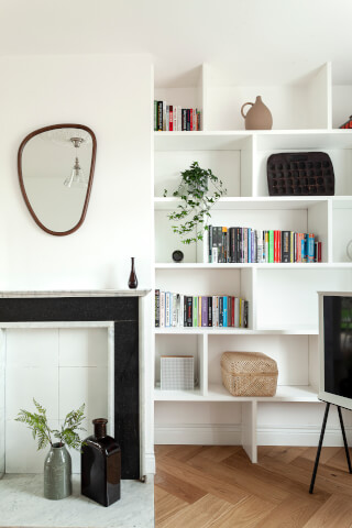 Cozy living room featuring a bookshelf, fireplace, and decor items, creating a serene interior space.