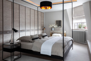 An elegant bedroom with a four-poster bed, built-in wardrobes, and minimalist decor.