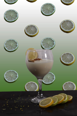 A cocktail in a glass, garnished with lemon slices and surrounded by citrus fruits, creates a vibrant and inviting scene.