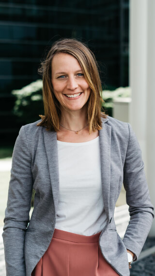 Smiling woman in blazer outside, embodying modern professionalism for leadership, corporate branding, and professional services.