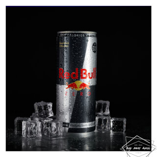 A can of Red Bull Zero with ice cubes against a black background, ideal for energy and hydration themes.