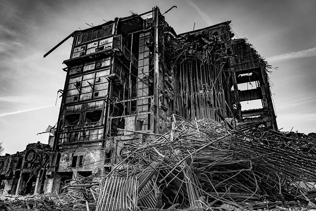 A demolished building stands amidst rubble and debris, showcasing the aftermath of destruction in an urban setting.