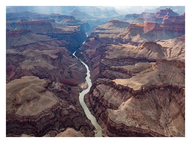 Aerial view of the Grand Canyon featuring the Colorado River winding through the vast canyon landscape.