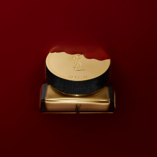 A luxury Yves Saint Laurent Or Rouge product on a red background. A high-end beauty and skincare item.